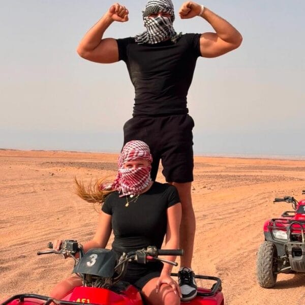 Quad 3 Hours Safari Hurghada featuring a man and woman posing energetically on a red quad bike