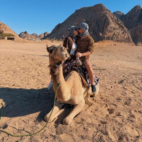 Quad 3 Hours Safari Hurghada featuring a couple enjoying a traditional camel ride in the desert