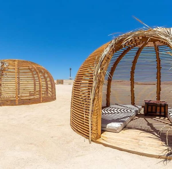 Luxury wooden lounge area on Eden Island, Hurghada, Egypt, featuring shaded seating with a direct view of the Red Sea's turquoise waters