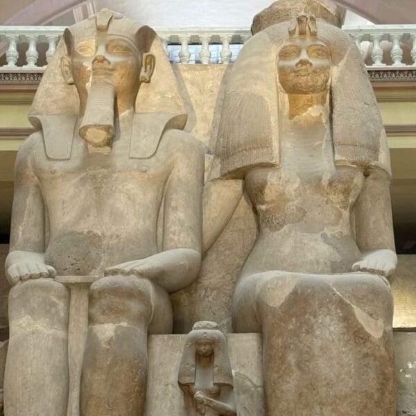 The massive limestone colossal statue of King Amenhotep III and Queen Tiye seated together at the Egyptian Museum in Cairo