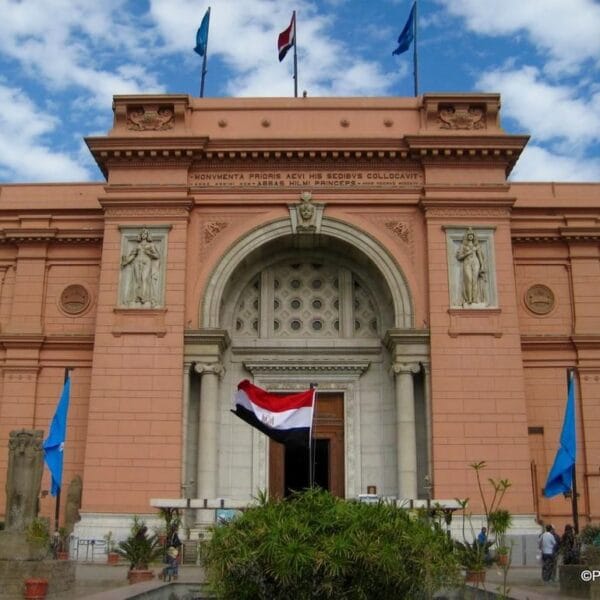 The iconic pink facade of the Egyptian Museum in Tahrir Square, Cairo, featuring classical architecture and the Egyptian flag
