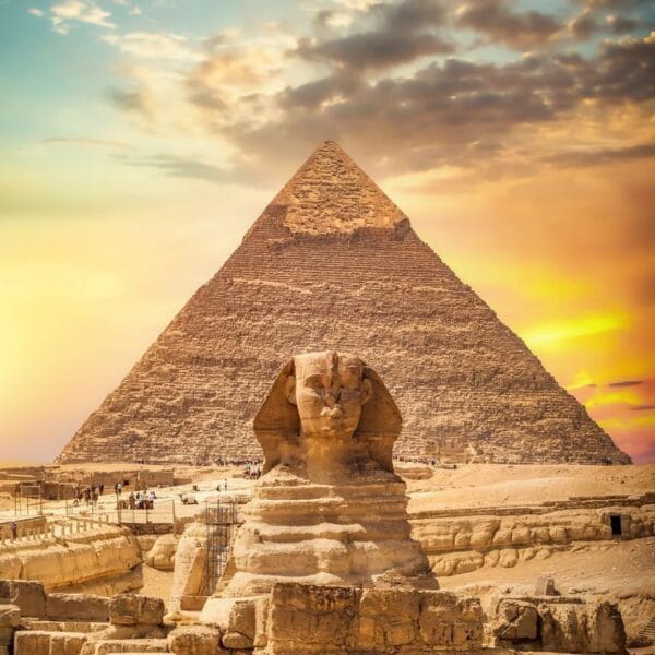 The Great Sphinx of Giza standing in front of the Pyramid of Khafre during a golden sunset on a Cairo day trip