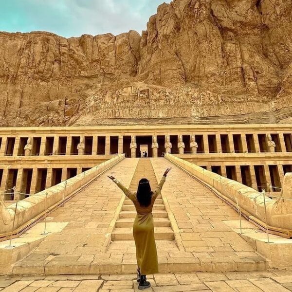 Luxor Over Day: A female tourist admiring the grand architecture and statues of the Mortuary Temple of Hatshepsut at Deir el-Bahari