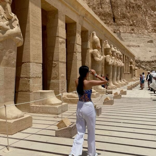 Luxor Over Day: A female tourist walking past the impressive Osiride statues of Queen Hatshepsut at her mortuary temple in Deir el-Bahari