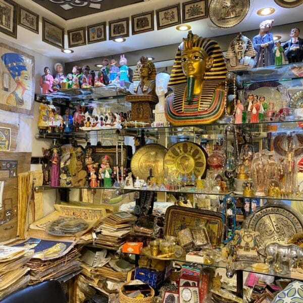 Luxor Over Day: A vibrant souvenir shop in Luxor displaying golden Tutankhamun masks, papyrus paintings, and various ancient Egyptian replicas