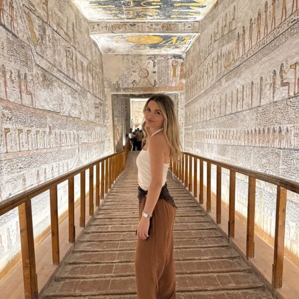 Luxor Over Day: A tourist exploring the interior of an ancient pharaonic tomb with stunning ceiling paintings in the Valley of the Kings