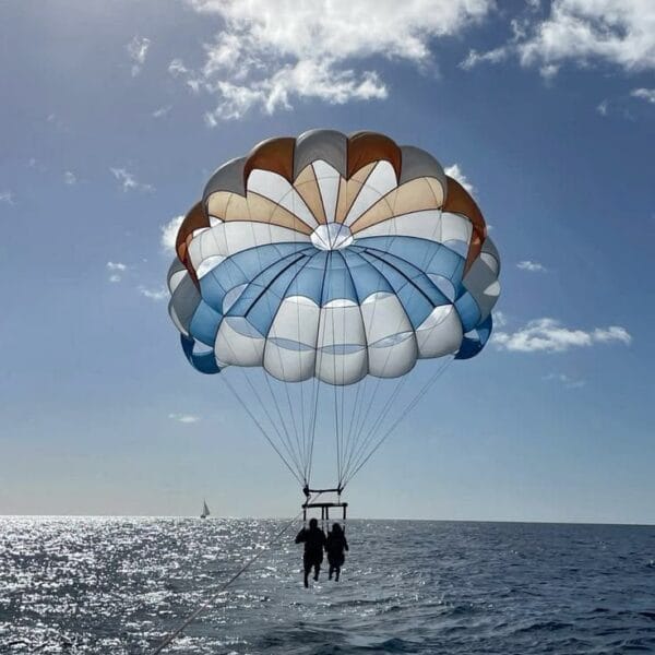 Parasailing Hurghada: Two people enjoying a tandem parasailing flight with a large colorful parachute over the sparkling Red Sea