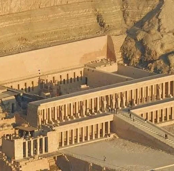 An aerial view of the multi-tiered Mortuary Temple of Hatshepsut built into the limestone cliffs at Deir el-Bahari, Egypt.
